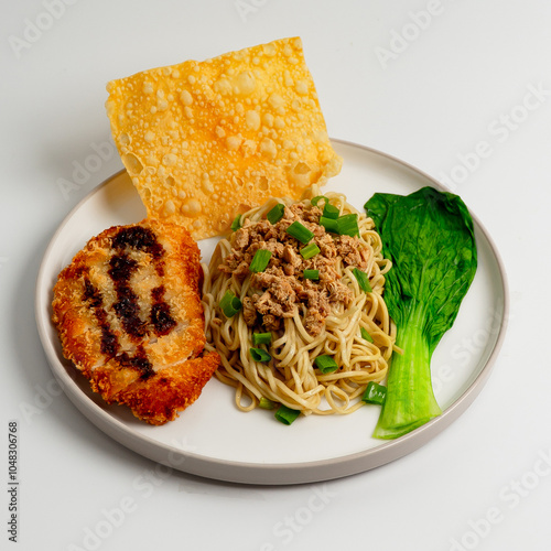 Mie ayam katsu, Noodles with chicken, chicken katsu, dumplings and vegetables is Indonesia popular food. White background, selective focus. photo