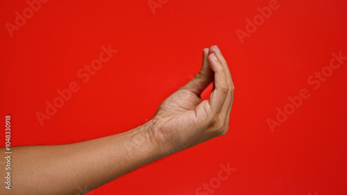 Obraz na plátně Man making the italian hand gesture against a vibrant red background, highlighting cultural expression and communication through body language