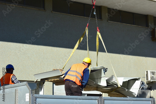 Operai al lavoro: sollevamento e posizionamento di materiali con gru al cantiere
