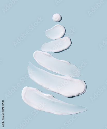 The concept of a Christmas tree in the form of cosmetic touches on a blue background. Winter concept. Skin care.