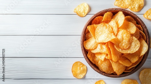 A visually appealing wooden bowl of golden potato chips set upon a white wooden table, with a rustic yet chic presentation perfect for casual snacking moments.