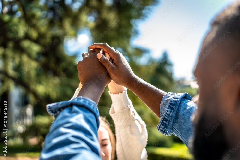 Fototapeta premium Multi-ethnic couple holding hands in a park