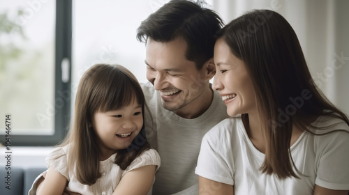 A family of three smiling at each other.