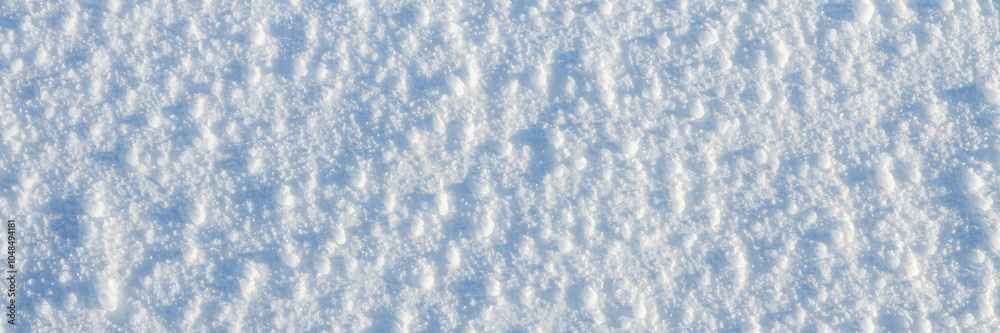 Natural snow texture. The surface of an icy snow crust. Snowy ground. Winter background with snow patterns. Perfect for Christmas and New Year design. Closeup top view.