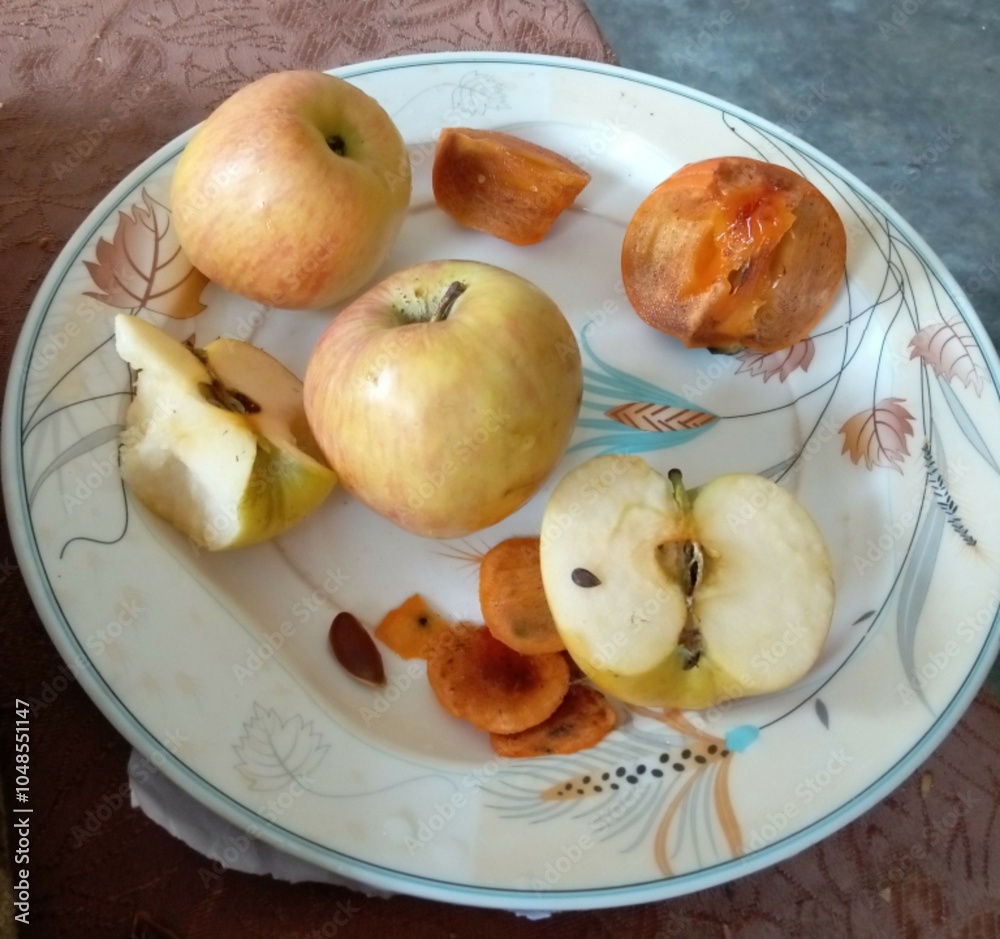 apples on a plate and japani fruit apples on a plate and japani fruit