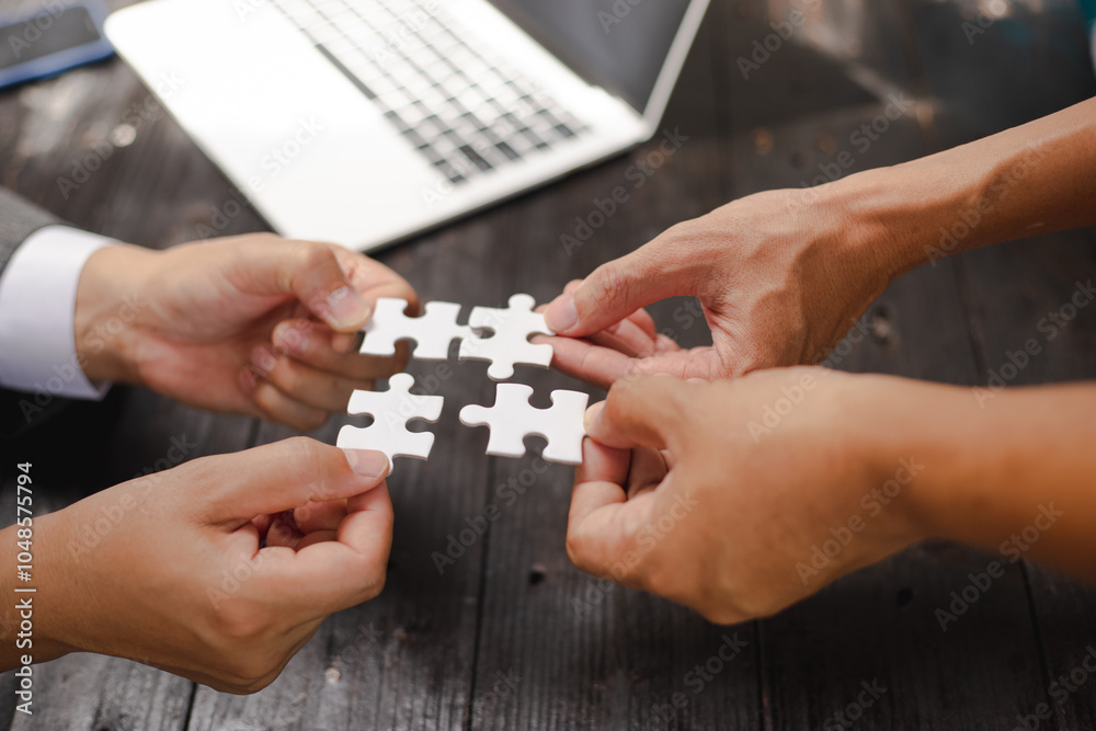 Businessman sitting at a table intently completing a jigsaw puzzle, demonstrating problem-solving, strategic thinking, and business decision-making, as well as attention to detail and patience. Businessman sitting at a table intently completing a jigsaw puzzle, demonstrating problem-solving, strategic thinking, and business decision-making, as well as attention to detail and patience.