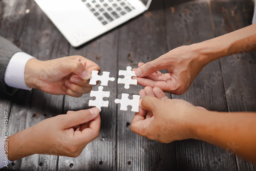 Businessman sitting at a table intently completing a jigsaw puzzle, demonstrating problem-solving, strategic thinking, and business decision-making, as well as attention to detail and patience.