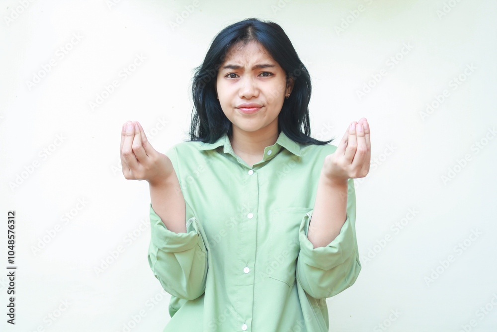 © M Alfan Setyawan - clueless asian woman with dark hair looking at camera with confusion expression raising two palms sideways with curled up finger wearing green oversized shirt, showing and presenting gesture © M Alfan Setyawan - clueless asian woman with dark hair looking at camera with confusion expression raising two palms sideways with curled up finger wearing green oversized shirt, showing and presenting gesture