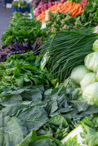 Fresh variety of leafy greens at a vibrant farmers market in the morning sun