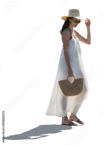 Backlit woman in a light summer beach dress and wearing a hat walking isolated on white background