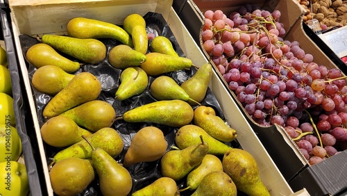 Fruits sur les étagères d'un magasin pour ventes, poires et raisins photo