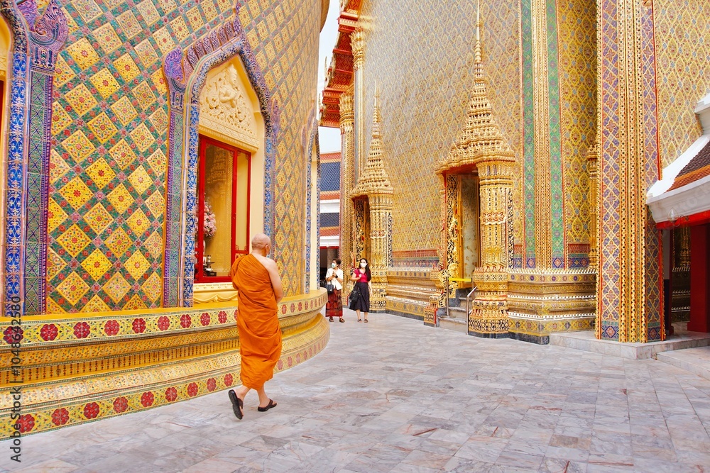 Fototapeta premium A Thai monk is walking in a beautiful craftsmanship and famous Buddhist temple of Wat Ratchabophit Sathitmahasimaram Ratchaworawihan in Bangkok, Thailand. A symbol of belief and worship in Buddhism