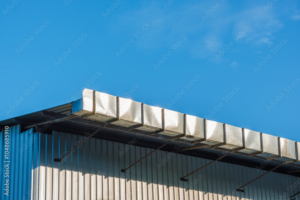 Roof gutter Metal sheet materials of a factory against blue sky. Roof gutter Metal sheet materials of a factory against blue sky.