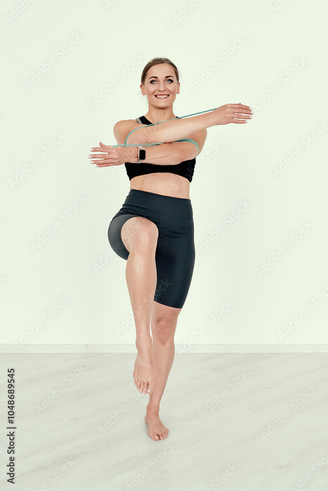 Female Trainer Stretching Resistance Band with Knee Raised. Female Trainer Stretching Resistance Band with Knee Raised.