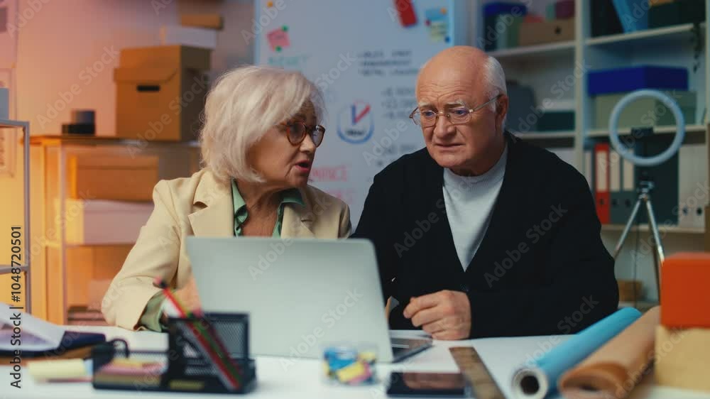 Upset business couple reading a bad news email about losing an important client Upset business couple reading a bad news email about losing an important client