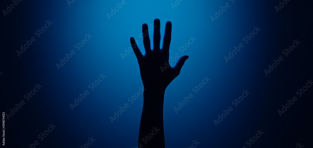 Silhouette of a hand reaching out against a blue background. Silhouette of a hand reaching out against a blue background.