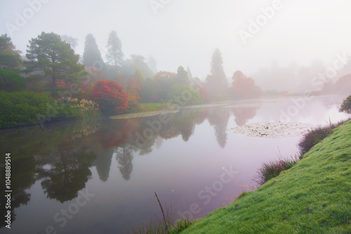 A Misty Autumn View Across The Lake To The Colourful Tree Lined Lake Shore