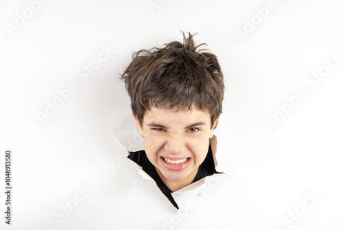 11 year old Brazilian child with only his head on a torn cardboard showing emotions_5. photo