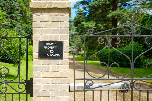 Private property sign seen at the automated entrance to a large, private gated community of luxury houses and apartments.