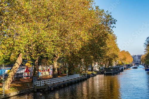 Picturesque cityscape with vibrant autumn colors of Amsterdam brick houses, trees, canals. Amsterdam, The Netherland. 