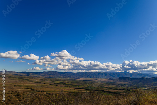 Sunny landscape with beautiful white clouds and settlements, Armenia-Georgia border 