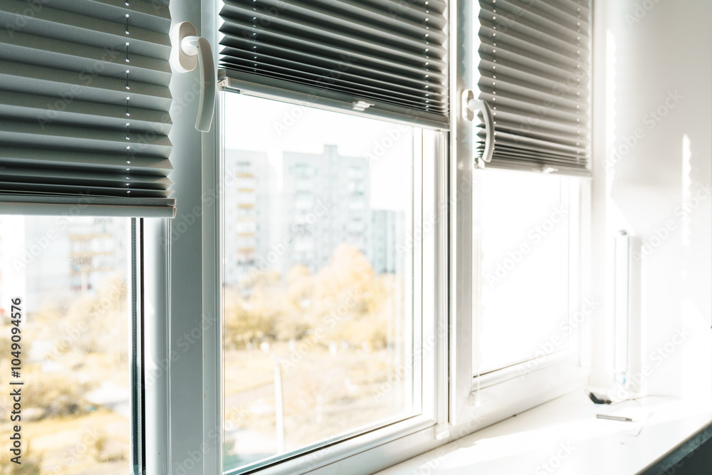 Fototapeta premium Gray blackout roller blinds on window indoors, closeup.
