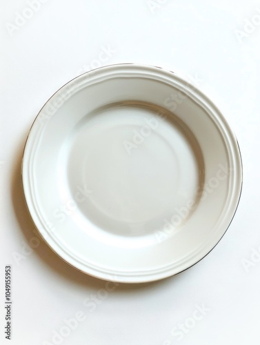 White plate with a black rim sits on a white background. The plate is round and has a simple design