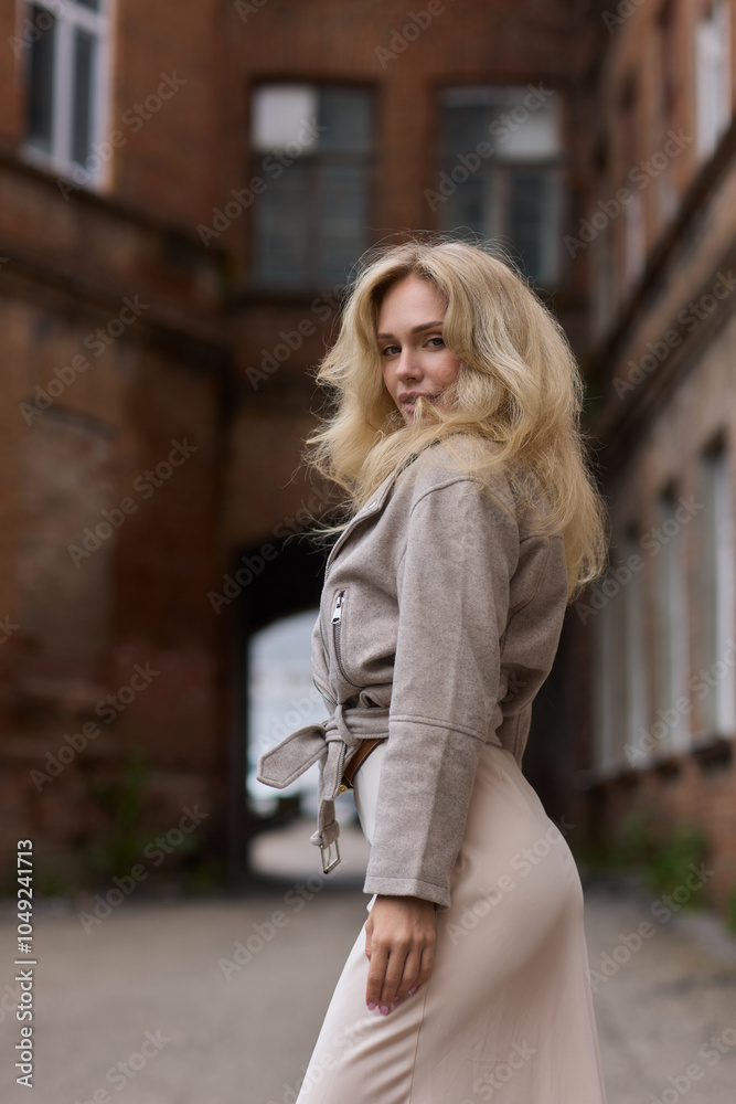 An elegant woman poses in an urban setting, showcasing her fashionable outfit with confidence An elegant woman poses in an urban setting, showcasing her fashionable outfit with confidence
