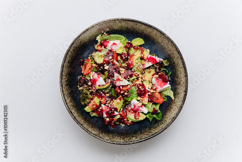 Fresh salad with goat cheese, avocado, and nuts topped with berry dressing for gourmet healthy dish photo