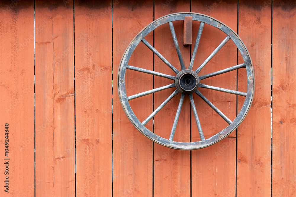 Old wagon wheel on rustic red wood background Old wagon wheel on rustic red wood background