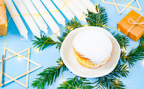 Donut, candles, star of David, spruce branches, garland and gifts on blue. photo