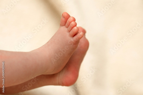 Close-up of a baby’s feet resting on soft fabric, capturing the innocence and smallness of early childhood on a quiet afternoon photo