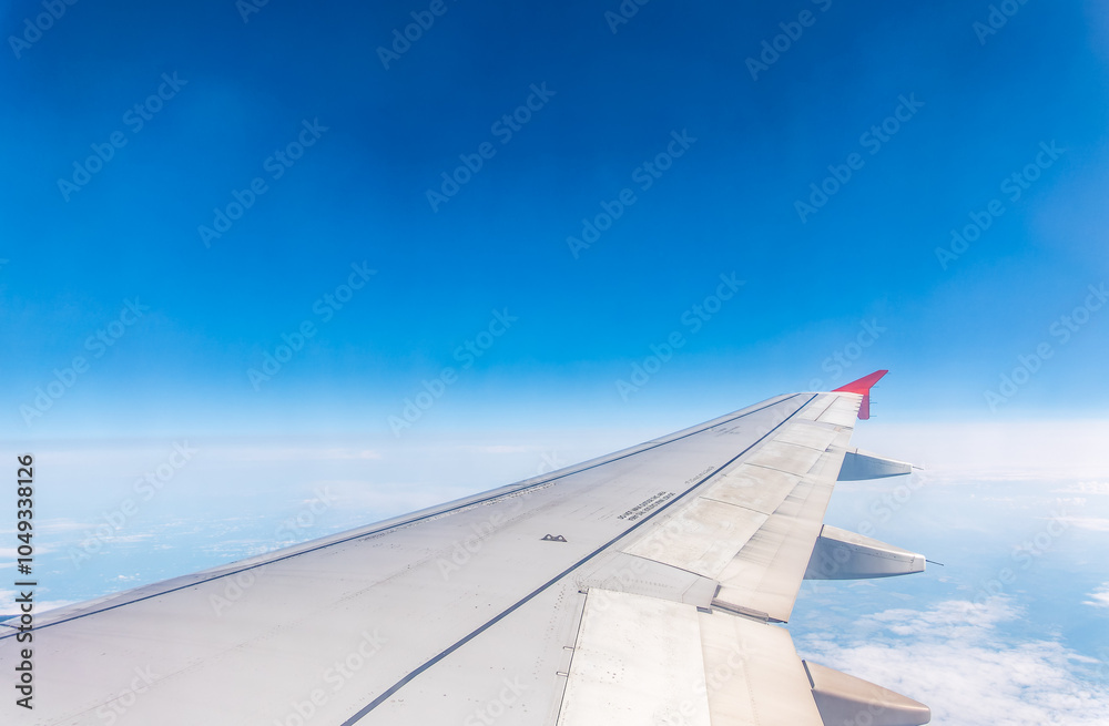 View from the airplane window at a beautiful cloudy sky and the airplane wing View from the airplane window at a beautiful cloudy sky and the airplane wing