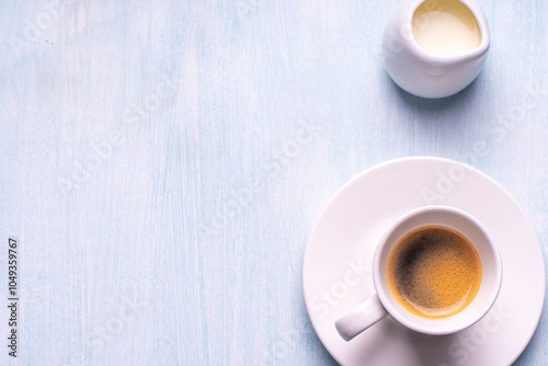 Espresso coffee cup and milk on a blue background. Top view. Space for text