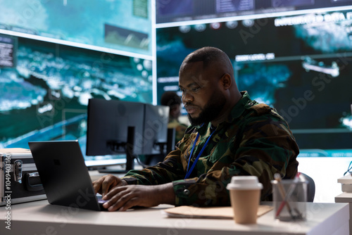 Secret service agent in an advanced control room handles surveillance activity, interpreting real time data for security measures to protect national interests. Specialist in base of operations. photo