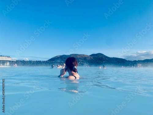 Tableau sur toile Reykjavik, ICELAND - April 6, 2023: girl in the blue lagoon with mountains in th