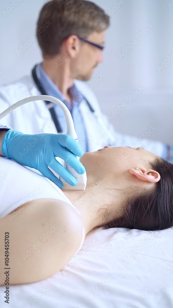 Doctor man wearing blue protective gloves is using ultrasound equipment on the neck of a patient woman, lying for examination. Medicine concept Doctor man wearing blue protective gloves is using ultrasound equipment on the neck of a patient woman, lying for examination. Medicine concept