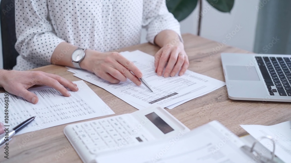 Fototapeta premium Professional female bookkeeper with a colleague are working on business finances. using calculator and laptop. Finance audit and taxes