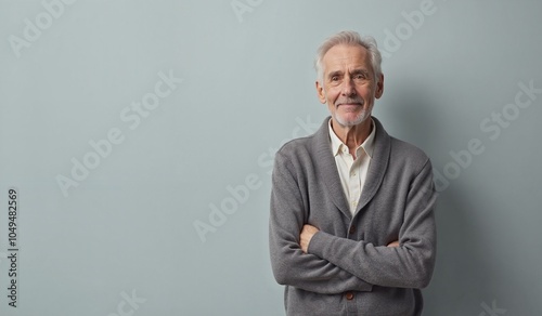 Senior man with confident smile posing against light blue wall with copy space photo