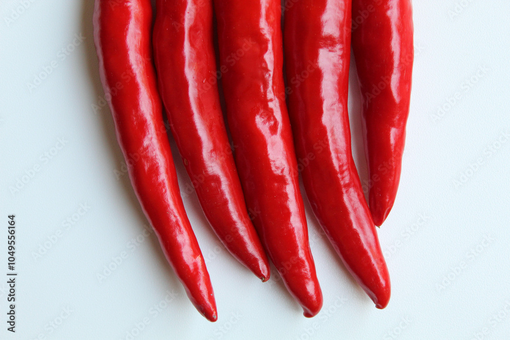 Some big red chillies line up, isolated on white background, flat lay or top view Some big red chillies line up, isolated on white background, flat lay or top view