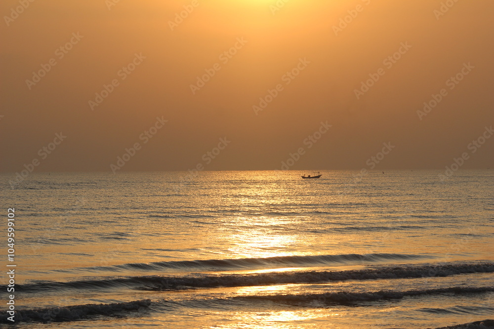 silhouette of a boat on the sea behind the red rising sun in the morning silhouette of a boat on the sea behind the red rising sun in the morning