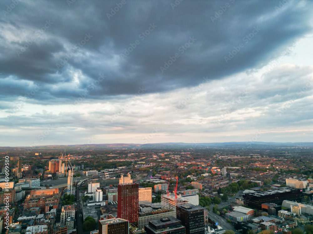 Fototapeta premium Aerial View of Greater Manchester City Centre and Tall Buildings During Golden Hour of Sunset, England UK. High Angle View Was Captured with Drone's Camera on the day of May 5th, 2024