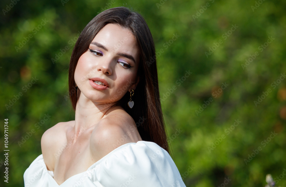 Naklejka premium Portrait of a brunette girl outdoors in summer