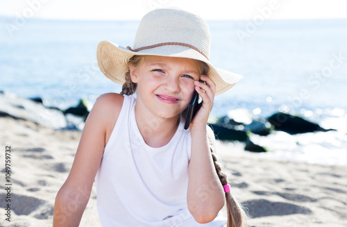 Baby girl with smartphone on sea photo