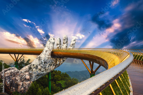 Beautiful Golden Bridge or Hand of Gods at the Ba Na Hills amusement Park in Da Nang in Vietnam on the mountain at sunset in summer photo