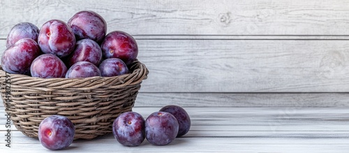 Fresh purple plums in a wic...