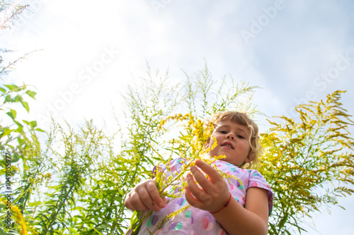 Child in ragweed flowers allergy. Selective focus.