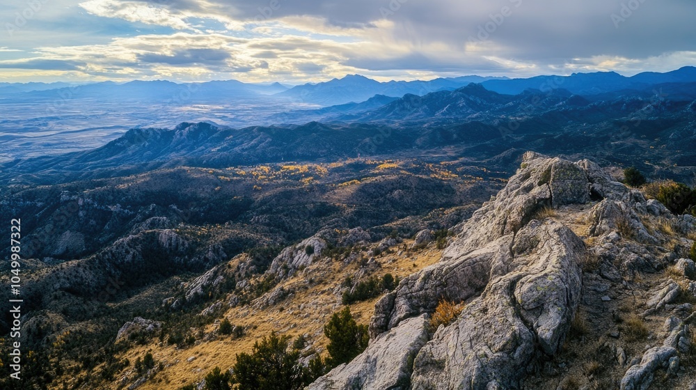 Mountain range with a cloudy sky in the background. The mountains are covered in trees and rocks Mountain range with a cloudy sky in the background. The mountains are covered in trees and rocks