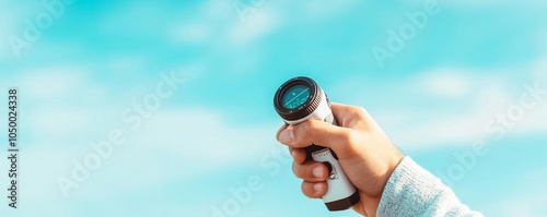 Golfer s hand adjusting a laser rangefinder for shot accuracy, blue sky overhead photo