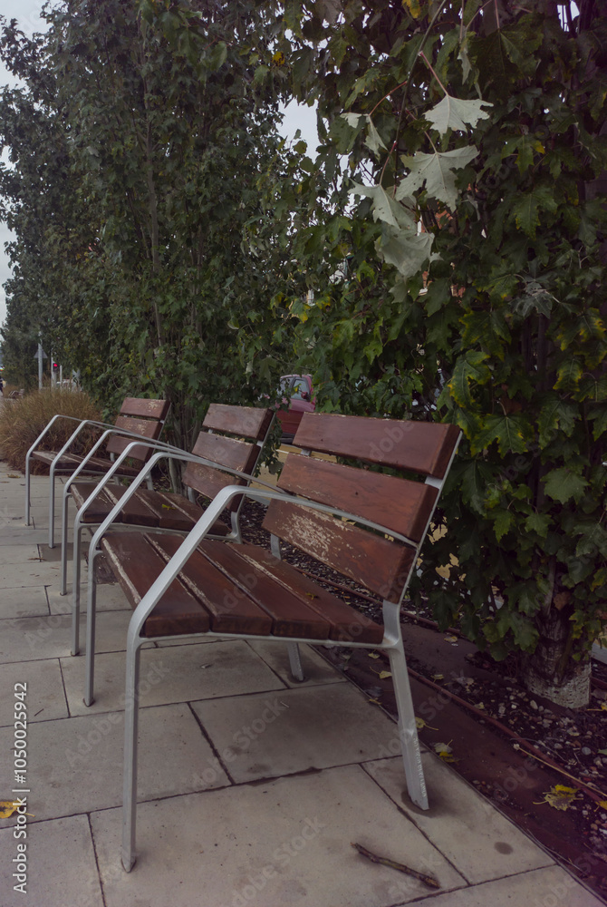 Several wooden chairs stand outside in the park. Several wooden chairs stand outside in the park.
